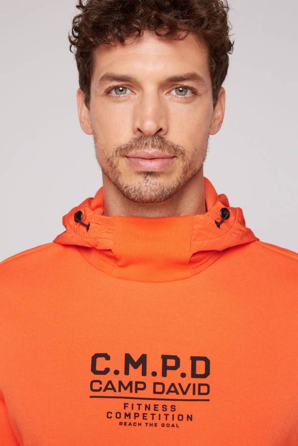 Soccx Hoodie im Materialmix mit Artwork und Rückentasche signal orange Im Verkauf